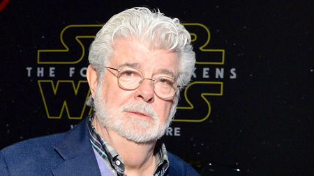 George Lucas in front of Star Wars: The Force Awakens poster.